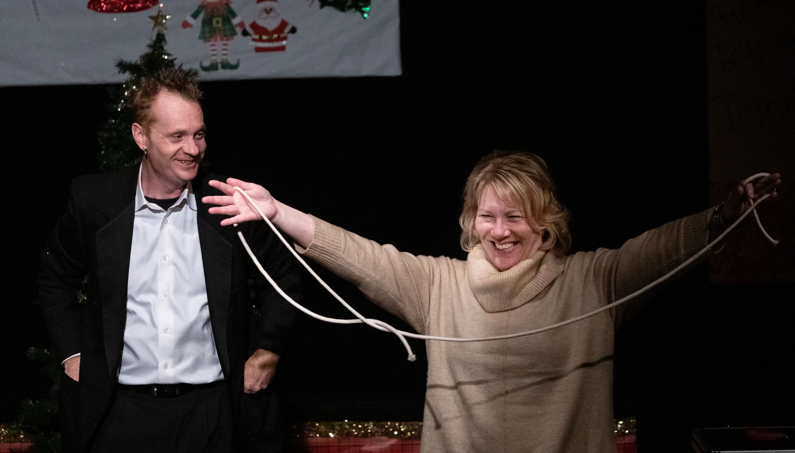 Kristian Charles performing on stage at Christmas event with audience member