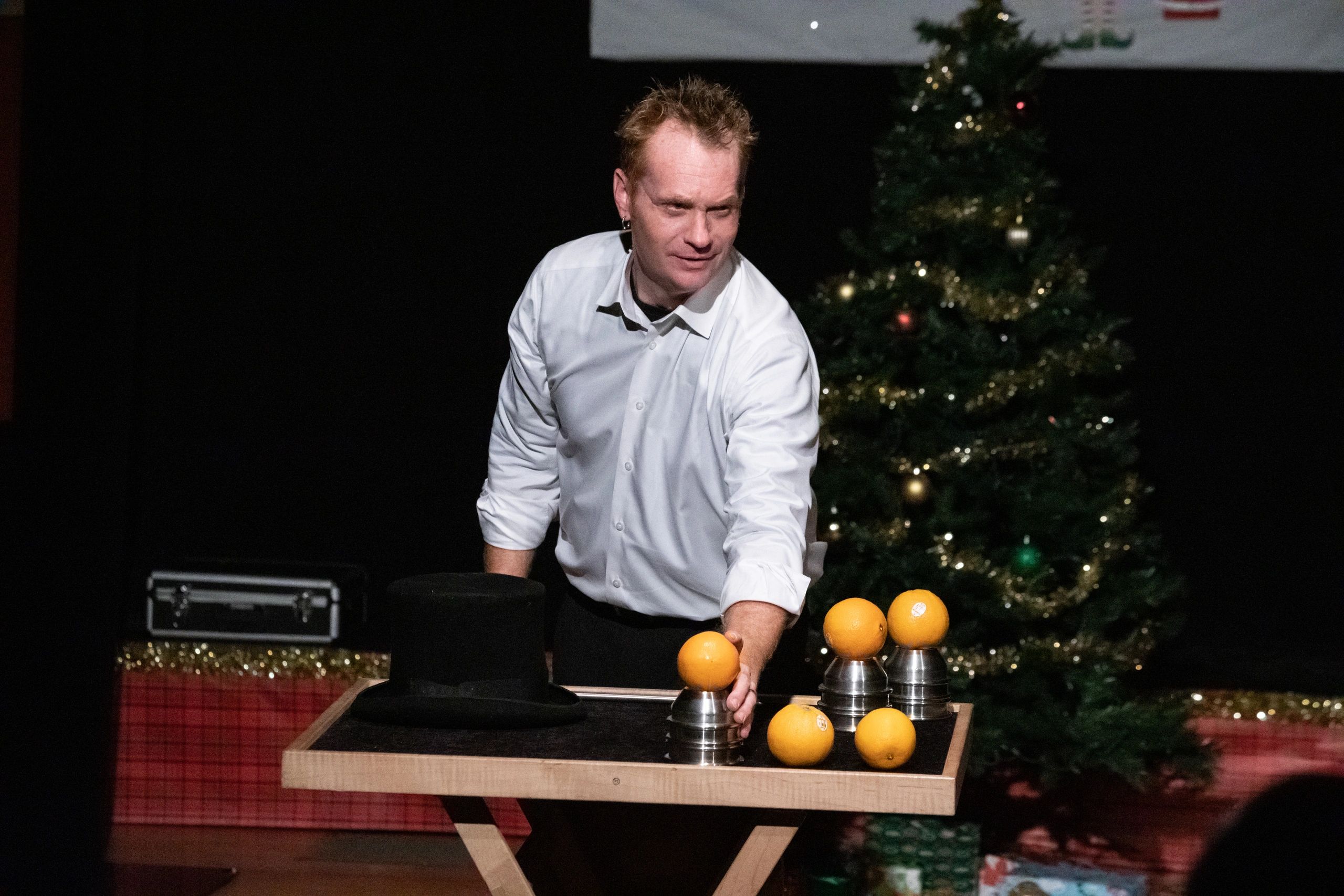 Kristian Charles performing magic with golden spheres at Christmas event